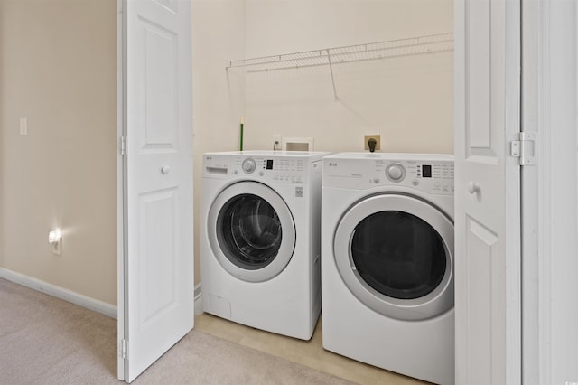 washroom featuring laundry area, light carpet, baseboards, and separate washer and dryer