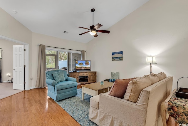 living area with ceiling fan, high vaulted ceiling, light wood-type flooring, and visible vents