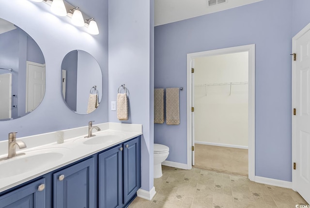 bathroom with visible vents, a sink, toilet, and double vanity