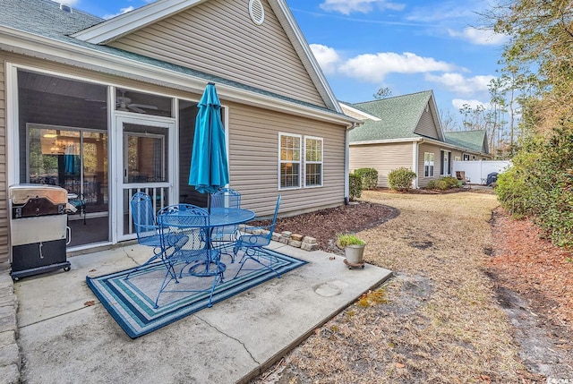 exterior space featuring a shingled roof, a patio area, and fence