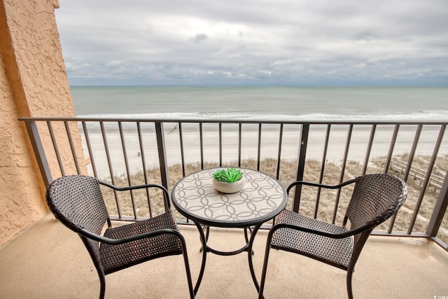 balcony featuring a water view and a beach view