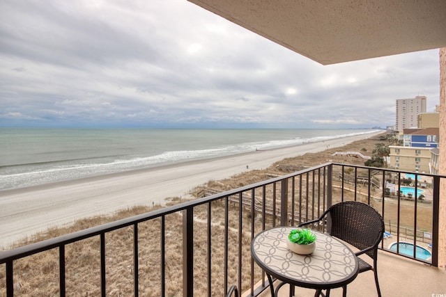 balcony featuring a beach view and a water view