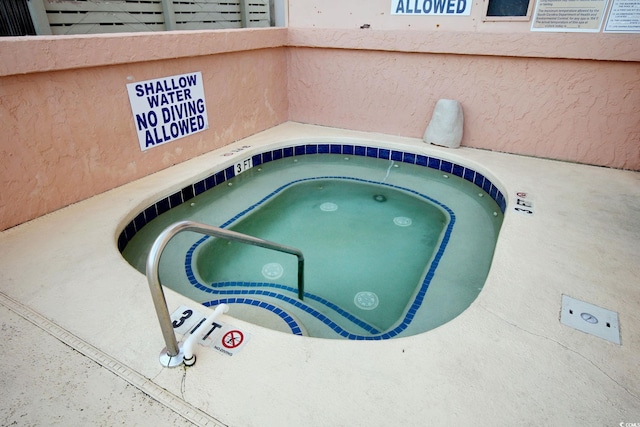 view of swimming pool featuring a hot tub