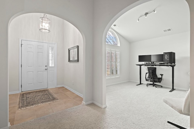 foyer featuring light carpet, visible vents, and vaulted ceiling