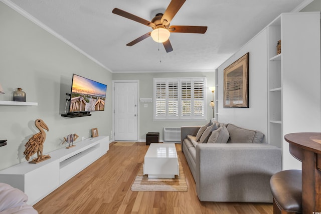 living area featuring light wood finished floors, ceiling fan, baseboards, and crown molding