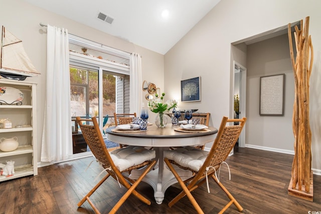 dining room featuring vaulted ceiling, dark wood finished floors, visible vents, and baseboards