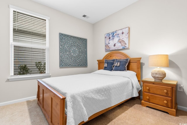 bedroom with light carpet, visible vents, and baseboards