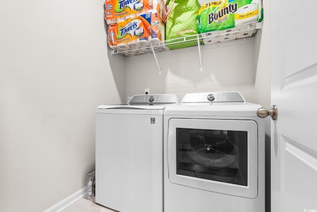 laundry area with laundry area, separate washer and dryer, and baseboards