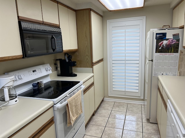 kitchen featuring white appliances, light countertops, and light tile patterned flooring