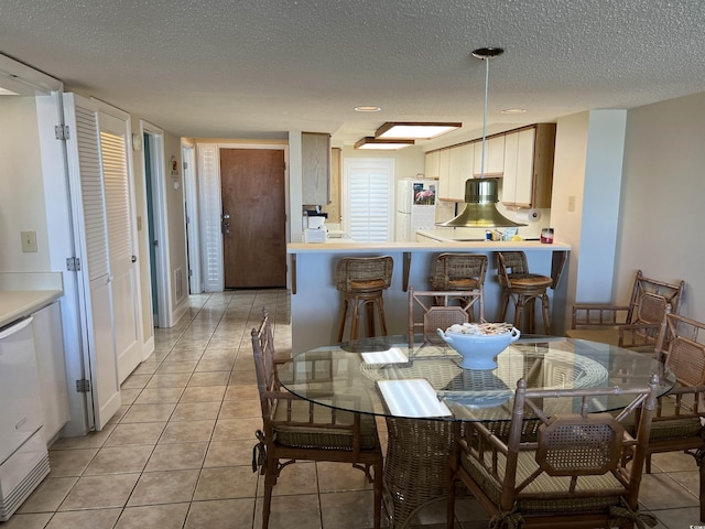 dining space featuring light tile patterned floors and a textured ceiling