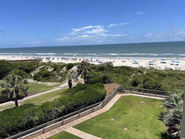 view of water feature featuring fence and a beach view