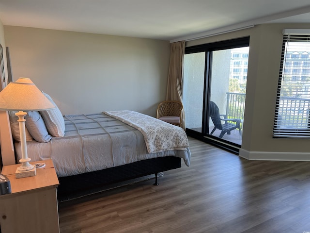 bedroom featuring access to outside, dark wood-style flooring, and baseboards