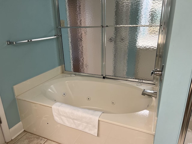 bathroom featuring baseboards, a whirlpool tub, and tile patterned floors