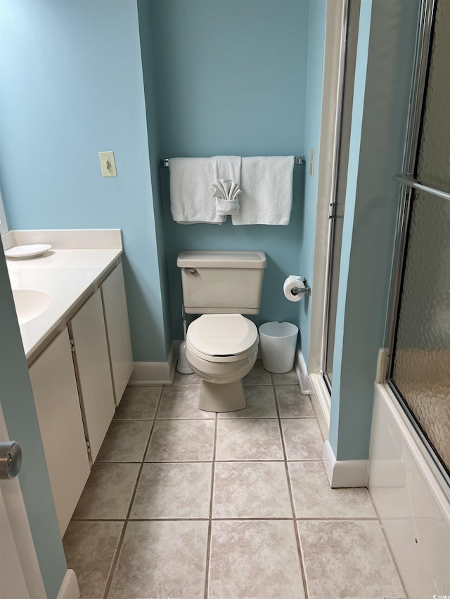 bathroom with baseboards, vanity, toilet, and tile patterned floors