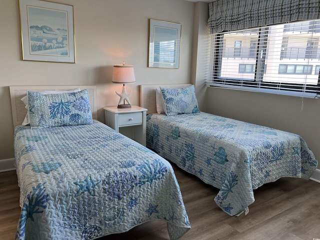 bedroom with baseboards and wood finished floors