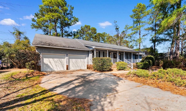 single story home featuring covered porch, concrete driveway, and an attached garage