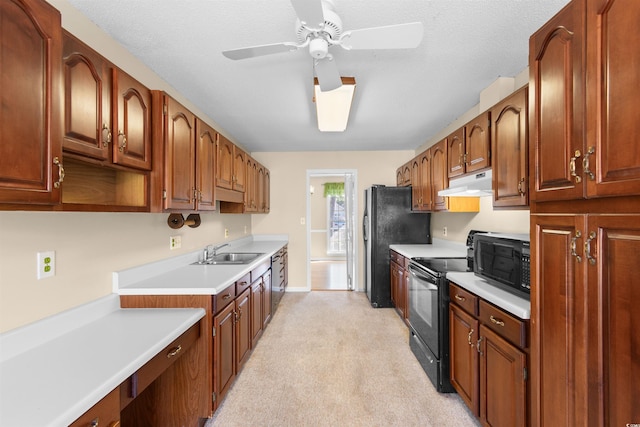 kitchen featuring under cabinet range hood, a sink, light countertops, brown cabinets, and black appliances