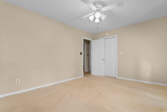 unfurnished bedroom with ceiling fan, baseboards, a closet, and light colored carpet