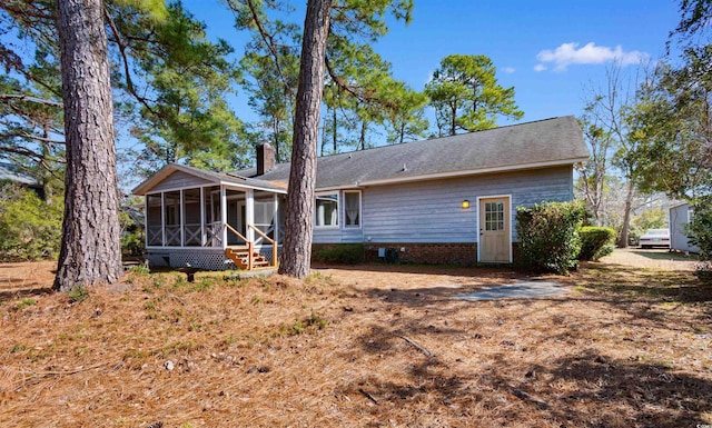 back of house with a sunroom and a chimney