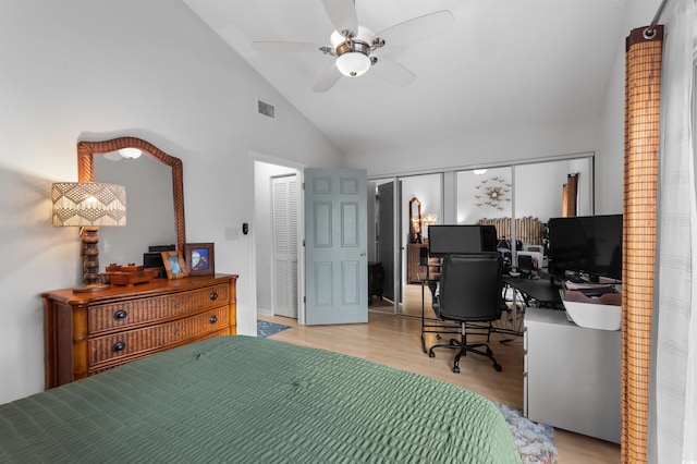 bedroom featuring a ceiling fan, visible vents, vaulted ceiling, and wood finished floors