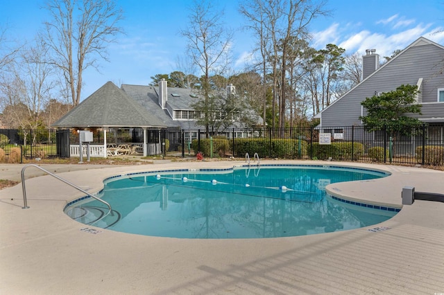 pool with a patio area and fence