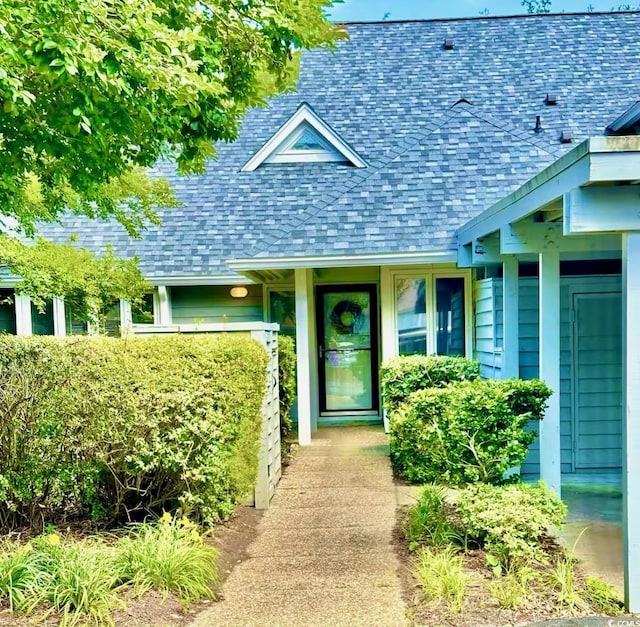 property entrance featuring a shingled roof