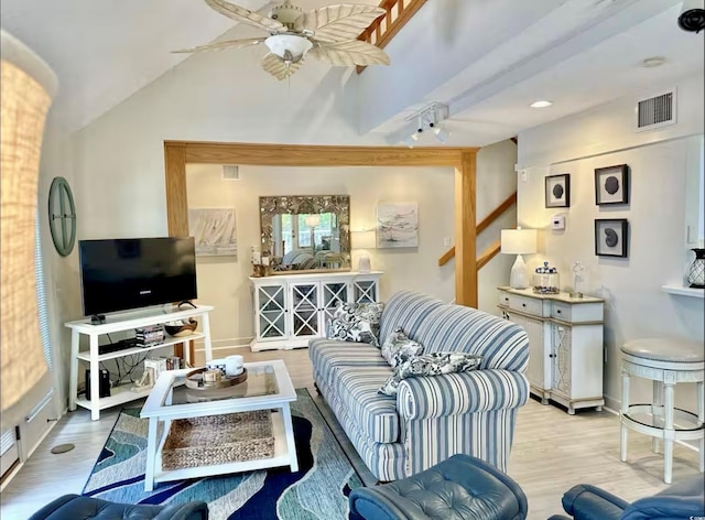 living room with vaulted ceiling, light wood finished floors, visible vents, and a ceiling fan