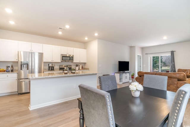 dining room with baseboards, light wood-style flooring, visible vents, and recessed lighting