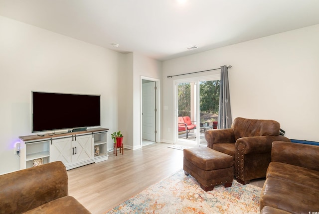 living room featuring baseboards, visible vents, and light wood-style floors