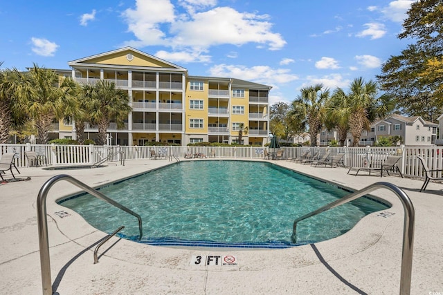 pool featuring fence and a patio