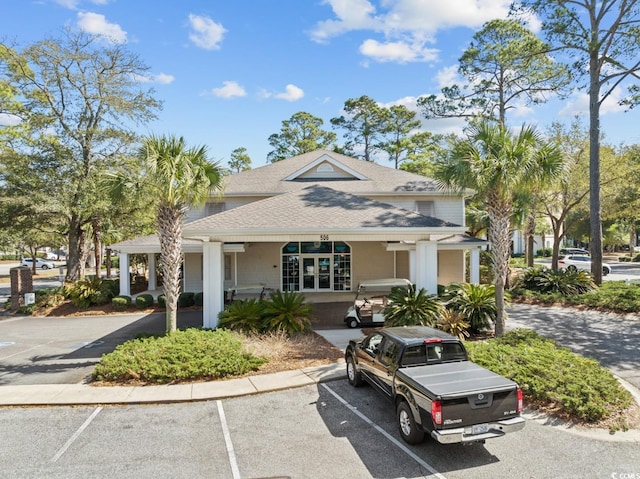 view of front of home featuring uncovered parking and roof with shingles