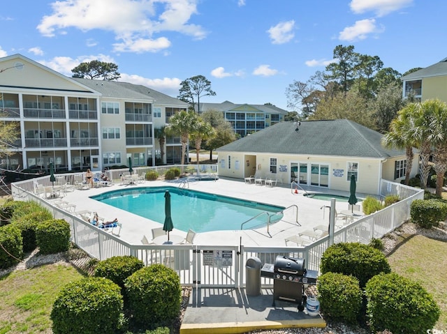 pool with a patio area, fence, and grilling area