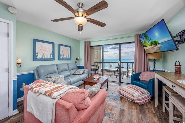 living area featuring ceiling fan, baseboards, and wood finished floors