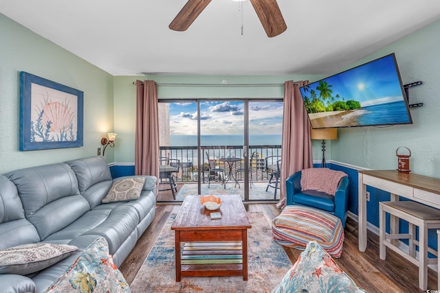 living area featuring ceiling fan, wood finished floors, and a textured wall