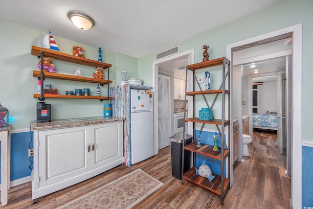 kitchen with visible vents, open shelves, dark wood-type flooring, and freestanding refrigerator