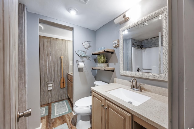 full bath with wood finished floors, walk in shower, vanity, and toilet