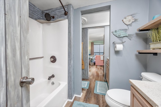 full bathroom with baseboards, bathing tub / shower combination, toilet, wood finished floors, and vanity