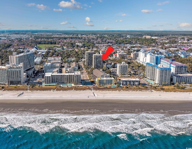 drone / aerial view featuring a beach view, a water view, and a city view