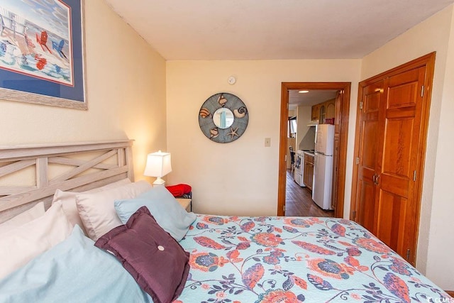 bedroom featuring a closet and freestanding refrigerator