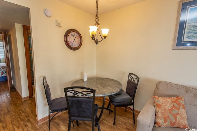 dining area featuring an inviting chandelier, wood finished floors, and baseboards