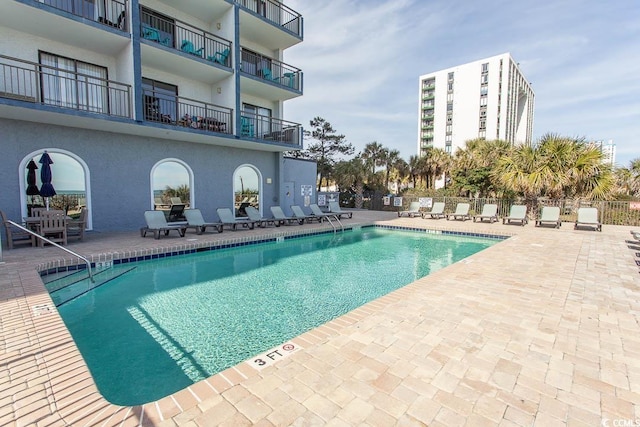 community pool with fence and a patio