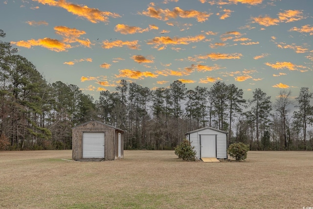 yard at dusk with a shed and an outdoor structure