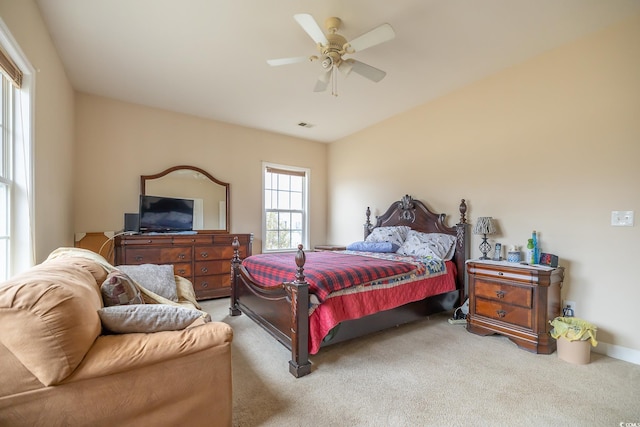 bedroom with a ceiling fan, visible vents, and light colored carpet