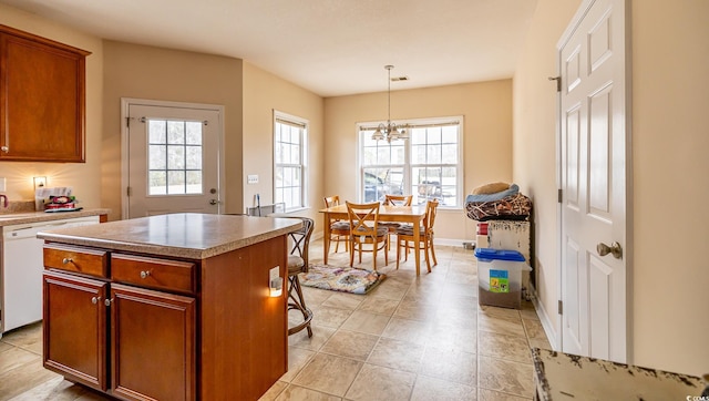 kitchen featuring a kitchen island, visible vents, light countertops, and decorative light fixtures