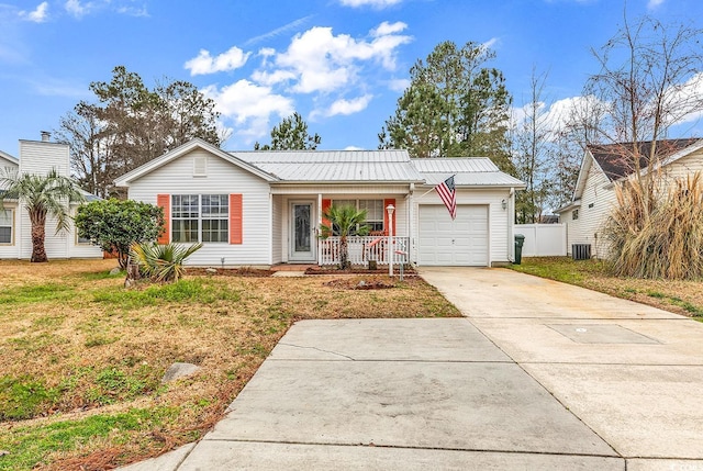 ranch-style house featuring metal roof, a porch, an attached garage, concrete driveway, and a front yard