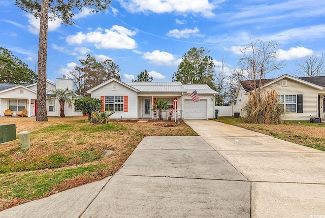 ranch-style house with concrete driveway, a front lawn, an attached garage, central AC unit, and metal roof