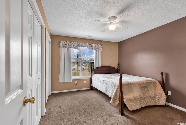 bedroom with ceiling fan, baseboards, a textured ceiling, and carpet floors