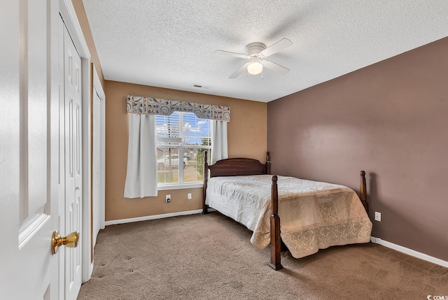 bedroom featuring visible vents, a textured ceiling, baseboards, and carpet flooring