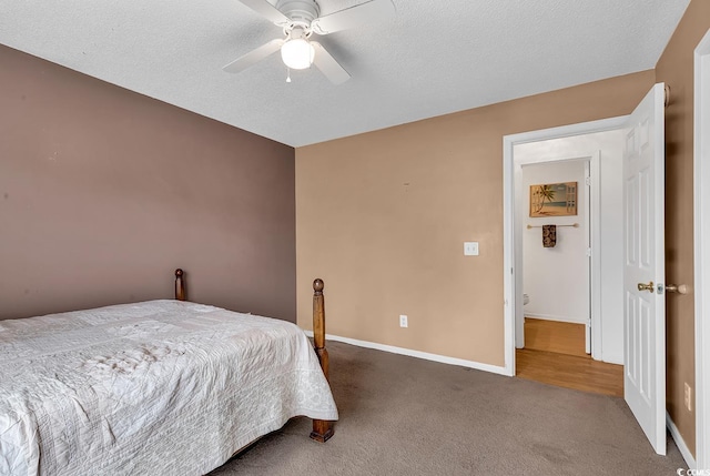 bedroom featuring dark colored carpet, ceiling fan, a textured ceiling, and baseboards