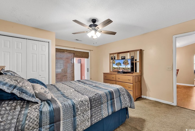 bedroom with a textured ceiling, a closet, visible vents, and light colored carpet